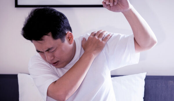 Asian middle aged man suffering from frozen shoulder,pain and stiffness,unable to move,difficulty lifting his arm,male people with calcific tendonitis or shoulder injuries,health care,medical concept