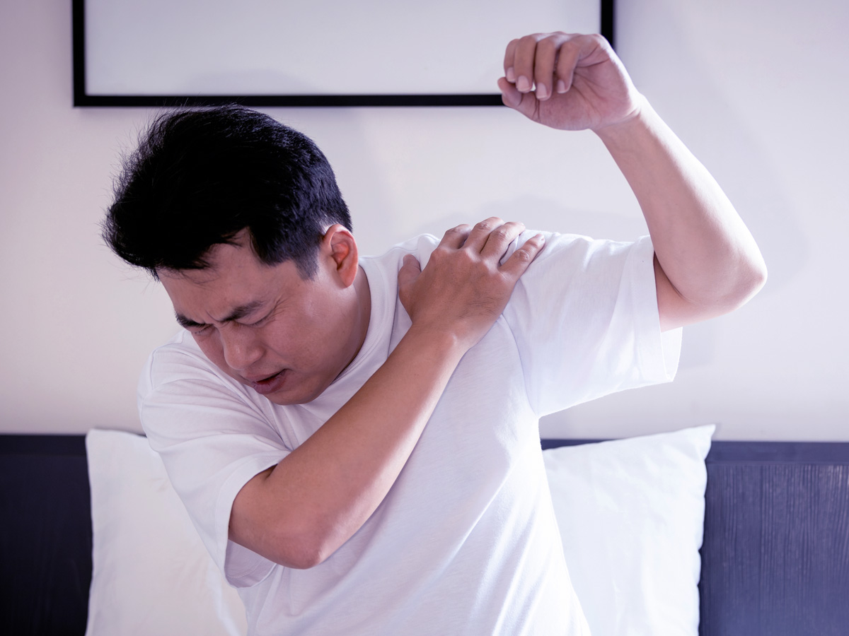 Asian middle aged man suffering from frozen shoulder,pain and stiffness,unable to move,difficulty lifting his arm,male people with calcific tendonitis or shoulder injuries,health care,medical concept